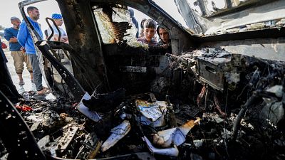 People inspect the site where World Central Kitchen workers were killed in Deir al-Balah, Gaza Strip, Tuesday, April 2, 2024. 