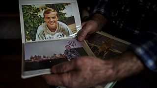 Oleksandr Turovskyi, il cui figlio Sviatoslav è stato ucciso a Bucha nel marzo 2022, guarda le foto del figlio nel suo appartamento di Bucha, in Ucraina (30 marzo 2024)