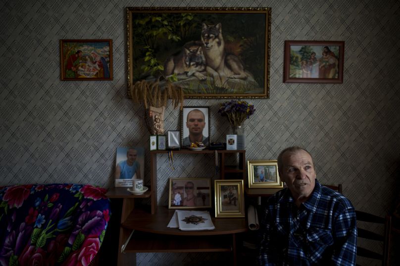 Oleksandr Turovskyi, whose son Sviatoslav was among eight men executed in Bucha in March 2022, sits next to pictures of his son at his apartment Saturday, March 30, 2024.