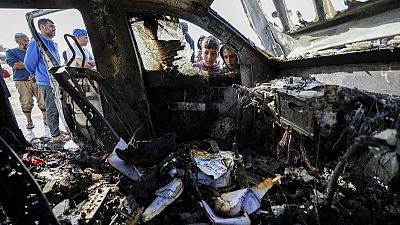 Un grupo de personas inspecciona el lugar del ataque israelí a los trabajadores de World Central Kitchen en Deir al-Balah, Franja de Gaza, el martes 2 de abril de 2024.