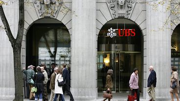 People follow the stock market boards at a branch of the UBS bank in Zurich's Bahnhofstrasse, Switzerland