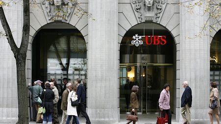 People follow the stock market boards at a branch of the UBS bank in Zurich's Bahnhofstrasse, Switzerland