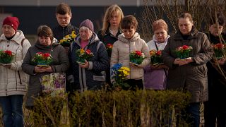 Relatives of those killed during the Russian occupation attend a commemoration of the victims at a cemetery in Bucha, Ukraine, Sunday, March 31, 2024.