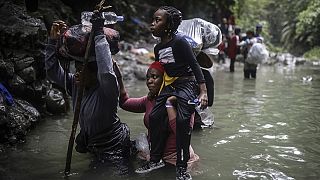 Migrantes haitianos caminan por el agua mientras cruzan el Tapón del Darién desde Colombia a Panamá con la esperanza de llegar a Estados Unidos, el 9 de mayo de 2023.