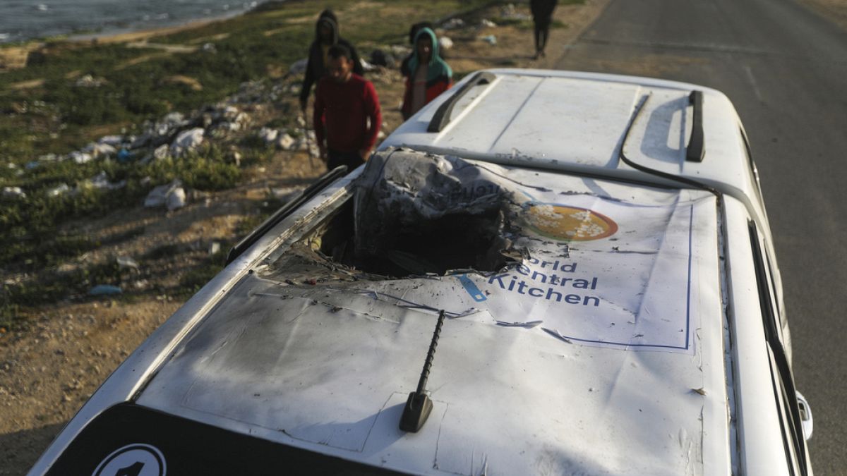 Palestinians inspect a vehicle with the logo of the World Central Kitchen wrecked by an Israeli airstrike in Deir al Balah, Gaza Strip, Tuesday, April 2, 2024