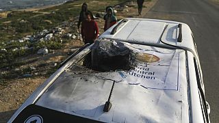 Palestinians inspect a vehicle with the logo of the World Central Kitchen wrecked by an Israeli airstrike in Deir al Balah, Gaza Strip, Tuesday, April 2, 2024. 