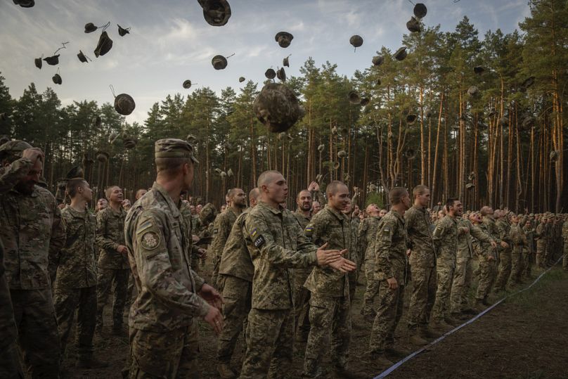 Newly recruited soldiers shout slogans as they celebrate the end of their training at a military base close to Kyiv, Ukraine, Monday, Sept. 25, 2023.