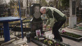 Olekszandr Turovszkij 35 éves fia, Szvjatoszláv sírját gondozza, aki azon nyolc férfi között volt, akiket 2022 márciusában kivégeztek egy üres telken Bucha külvárosában,