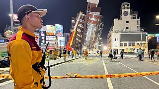A rescue worker stands near the cordoned off site of a leaning building in the aftermath of an earthquake in Hualien, eastern Taiwan on Wednesday, April 3, 2024.