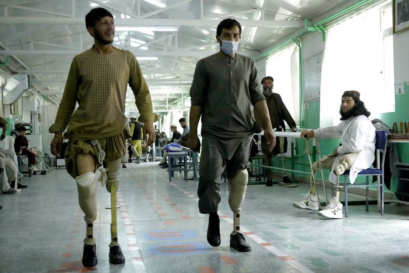 Afghan men who have lost their legs due to landmines learn to use their new prosthetics at the ICRC centre in Kabul, May 2022