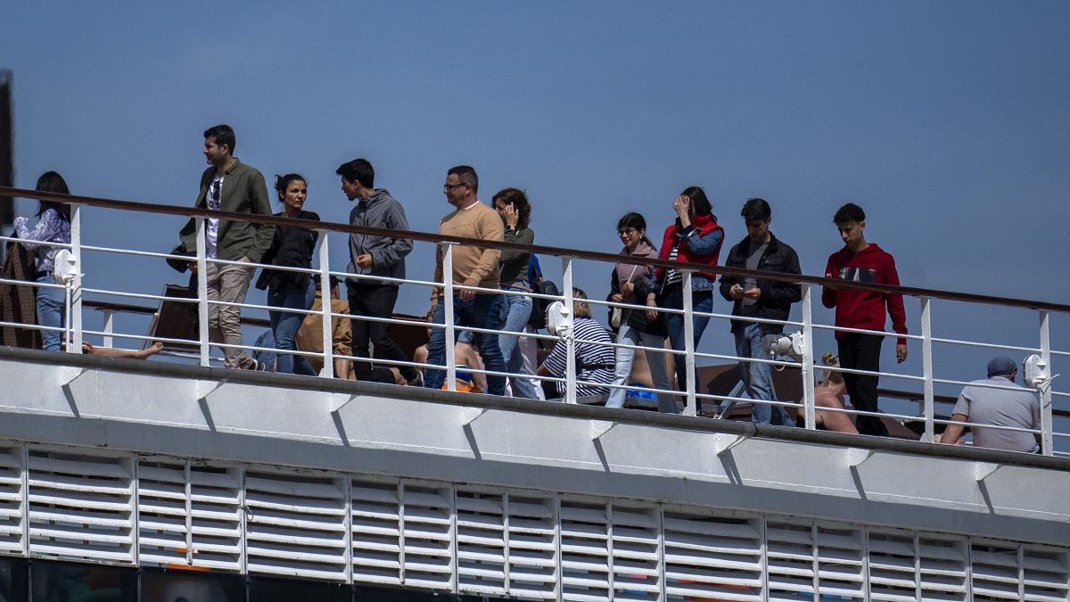 Os passageiros são fotografados no navio de cruzeiro MSC Armony, atracado no porto de Barcelona, Espanha, quarta-feira, 3 de abril de 2024.