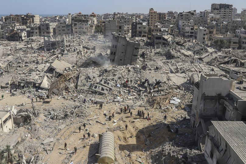 Palestinians walk through the destruction left by the Israeli air and ground offensive on the Gaza Strip near Shifa Hospital in Gaza City in April.