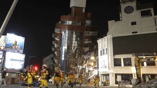 Los bomberos completan su misión y evacúan un edificio derrumbado durante una operación de rescate tras un terremoto en la ciudad de Hualien, en Taiwán, el miércoles.
