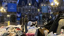 مهاجرون يقفون أمام قاعة مدينة باريس