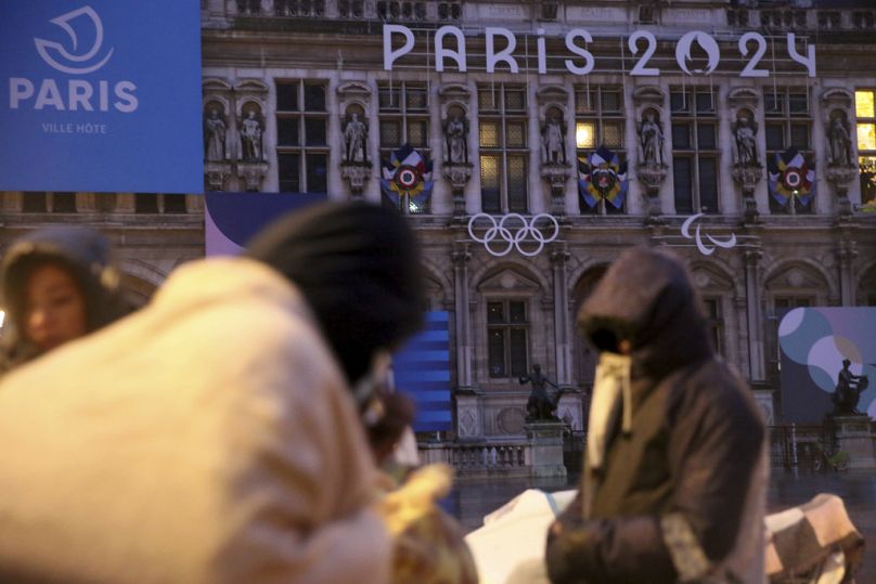 Migrants stand in front of the Paris City Hall, Wednesday, April 3, 2024.