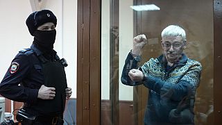 The co-chair of the Nobel Peace Prize winning Memorial Human Rights Centre Oleg Orlov gestures standing in a glass cage after he was taken into custody in the courtroom,Feb 23