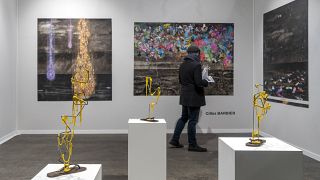 A visitor walks through the gallery Huberty & Breyne's stand at Art Paris 2024.