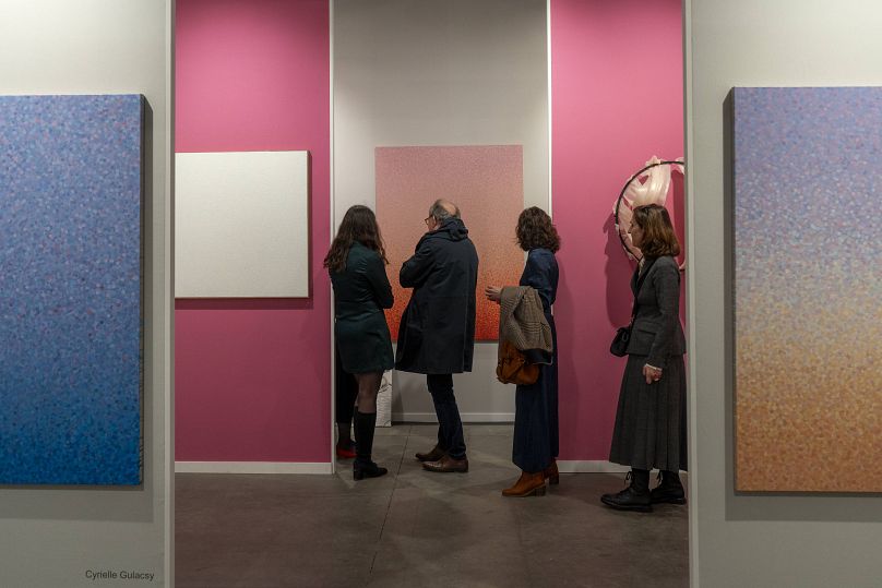 Visitors looking at artworks at the stand for Galerie Anne-Sarah Benichou at Art Paris 2024.