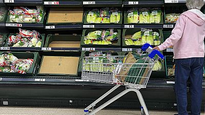 A shopper faces partly empty shelves in a supermarket in London, Thursday, Sept. 30, 2021. 
