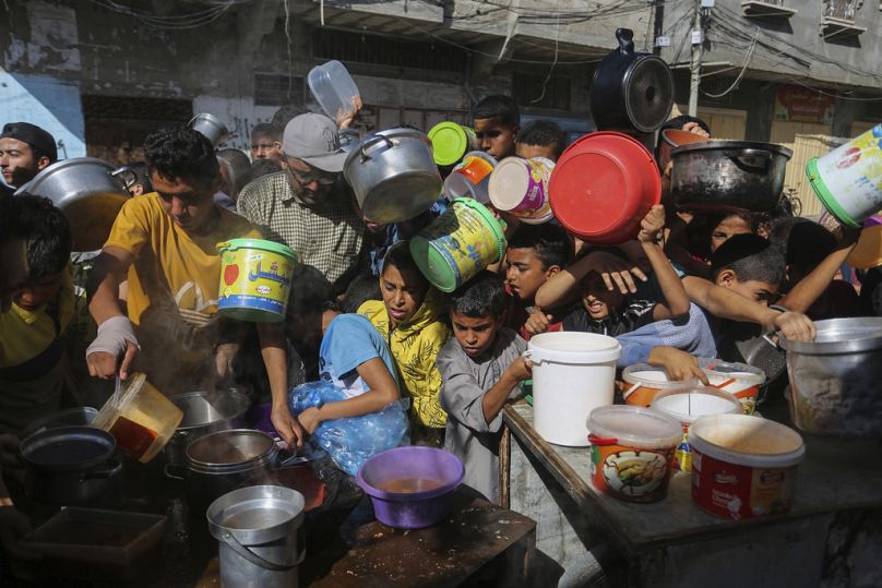 İsrail saldırıları altındaki Gazze'de gıda yardımı almak için sırada bekleyen Filistinliler