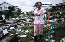 A woman stands beside the wreckage of her mother's home in Horseshoe Beach, Florida, hit by Hurricane Idalia in late August 2023.