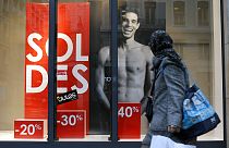 A woman looks at a store advertising for winter sales in Lyon, central France, Thursday, Jan. 7, 2016. 