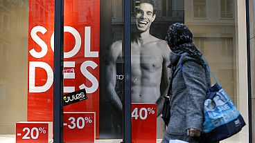 A woman looks at a store advertising for winter sales in Lyon, central France, Thursday, Jan. 7, 2016. 