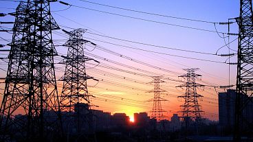Le soleil se couche entre les lignes électriques à Pékin, en Chine.