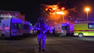 A Russian National Guard servicemen deployed near a massive blaze seen over the Crocus City Hall on the western edge of Moscow.