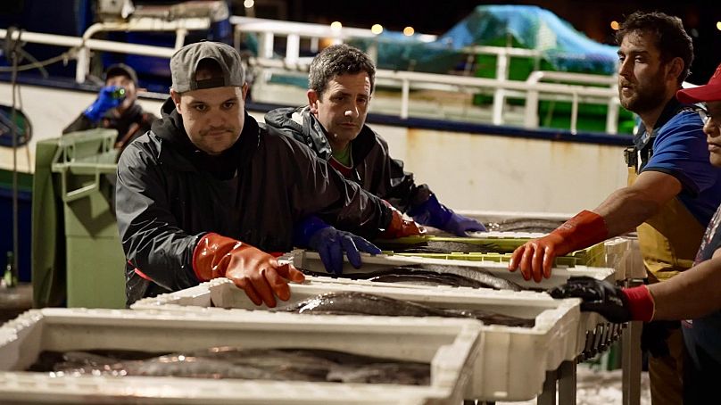 Crews working at Celeiro's fishing port can be seen throughout the night unloading crates of freshly caught hake from commercial vessels.