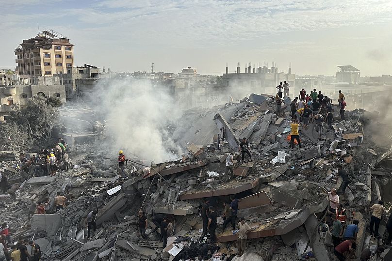 فلسطينيون يبحثون عن ناجين بعد غارة جوية إسرائيلية على مخيم النصيرات للاجئين في قطاع غزة، الثلاثاء 31 أكتوبر 2023.