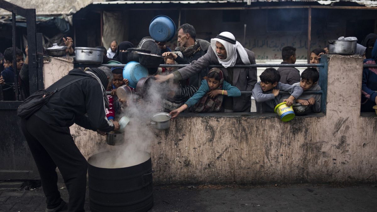 Palestinians line up for a free meal in Rafah, Gaza Strip