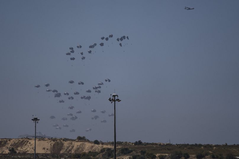 An aircraft airdrops humanitarian aid over northern Gaza Strip as seen from southern Israel