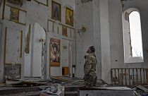 A Ukrainian serviceman prays kneeling in a church damaged in the Russian air raid in the town of Orikhiv, Zaporizhzhia region, Ukraine, Friday, Apr. 5, 2024.