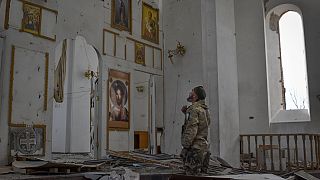A Ukrainian serviceman prays kneeling in a church damaged in the Russian air raid in the town of Orikhiv, Zaporizhzhia region, Ukraine, Friday, Apr. 5, 2024.