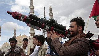 Un sostenitore degli Houthi tiene in mano un finto missile durante una manifestazione a Sana'a, nello Yemen (5 aprile 2024)