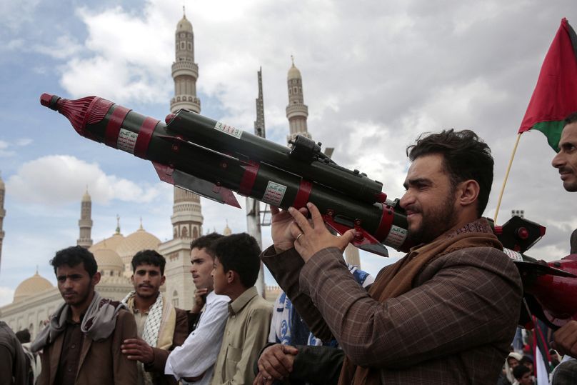 A Houthi supporter holds a mock missile during a protest in Sanaa, April 2024