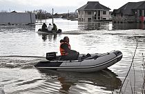 People use rubber boats in the flooded street after part of a dam burst, in Orsk, Russia. State media say Russia's government has declared the situation in flood-hit areas in 