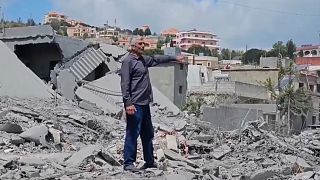 مواطن لبناني وسط الحطام في أحد المنازل المدمرة