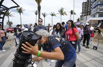 An amateur astronomer prepares her telescope a day before a total solar eclipse in Mazatlan, Mexico, Sunday, April 7, 2024.