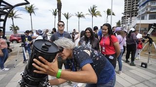 An amateur astronomer prepares her telescope a day before a total solar eclipse in Mazatlan, Mexico, Sunday, April 7, 2024.