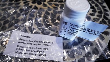 A prescription bottle named osimertinib (brand name: Tagrisso) is seen on a table.