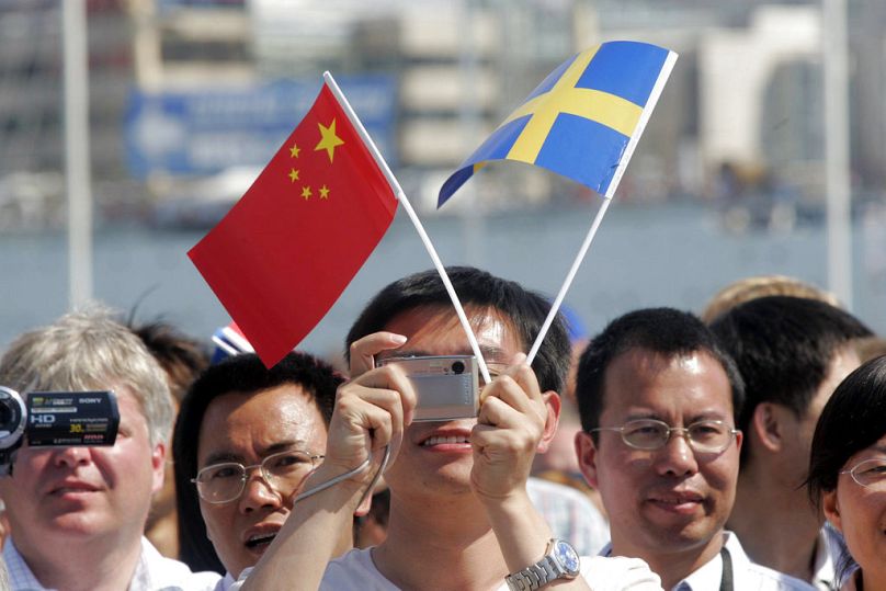 أشخاص يحملون الأعلام والكاميرات يستقبلون الرئيس الصيني هو جين تاو عند وصوله إلى ميناء غوتبورغ 2007