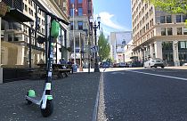 A Lime e-scooter sits parked on a street in downtown Portland, Ore., Thursday, May 9, 2019.