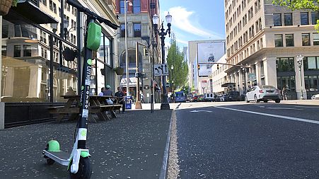 A Lime e-scooter sits parked on a street in downtown Portland, Ore., Thursday, May 9, 2019.