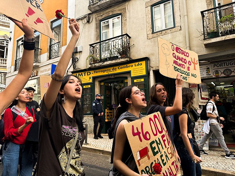 Jovens protestam em Lisboa numa marcha contra a precariedade em março. Seguram cravos, símbolo da revolução