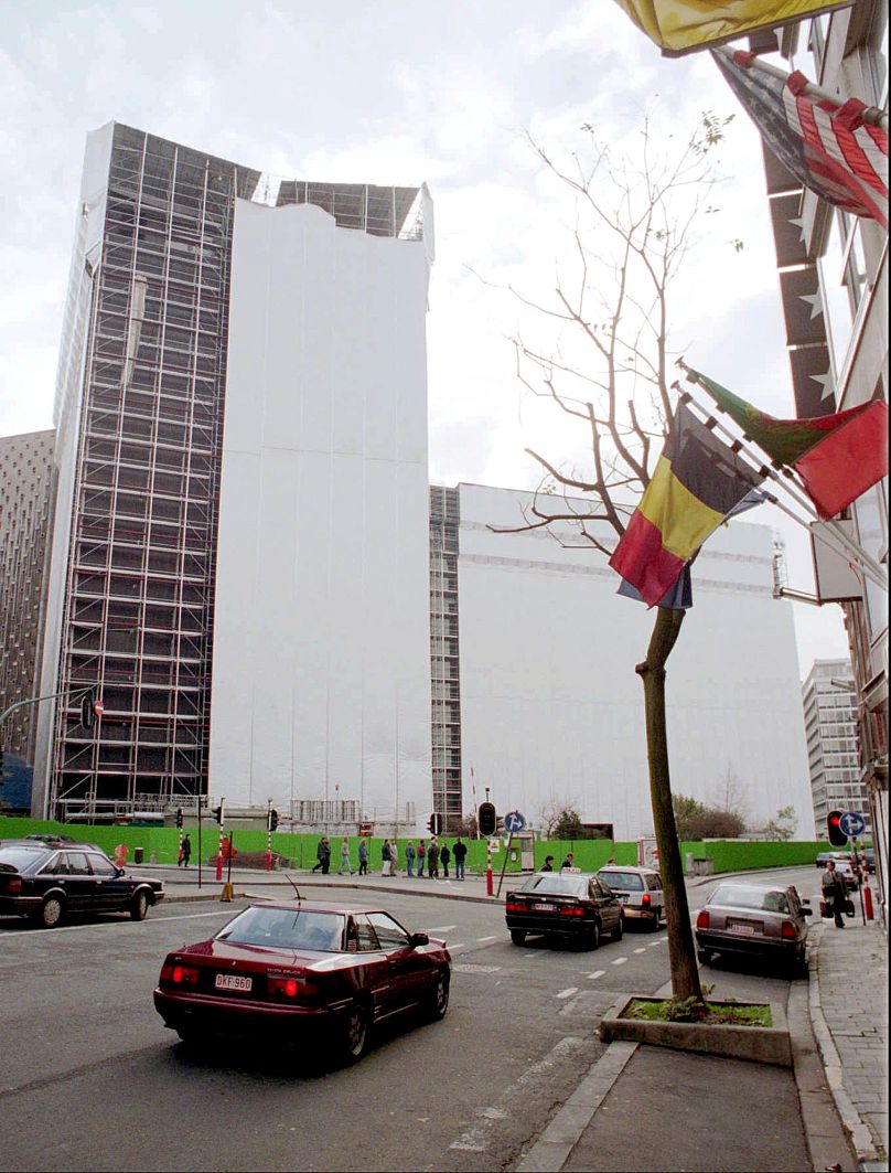 The European Commission's Berlaymont building is seen partially wrapped with plastic sheets in preparation to remove asbestos, in Brussels, November 1995