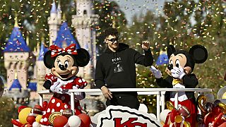 Kansas City Chiefs quarterback Patrick Mahomes, center, greets fans on Main Street, U.S.A, during a cavalcade through Disneyland in Anaheim, Calif., Monday, Feb. 12, 2024. 