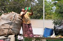 Eine Müllsammlerin löscht ihren Durst, während sie an einem heißen Tag in Hyderabad, Indien, am 12. März 2024 auf einem Lastwagen steht.