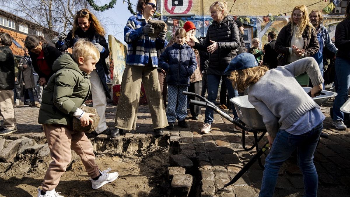 Los ciudadanos de la aldea libre Christiania desentierran conjuntamente los adoquines de Pusher Street, en Copenhague, Dinamarca, el sábado 6 de abril de 2024.